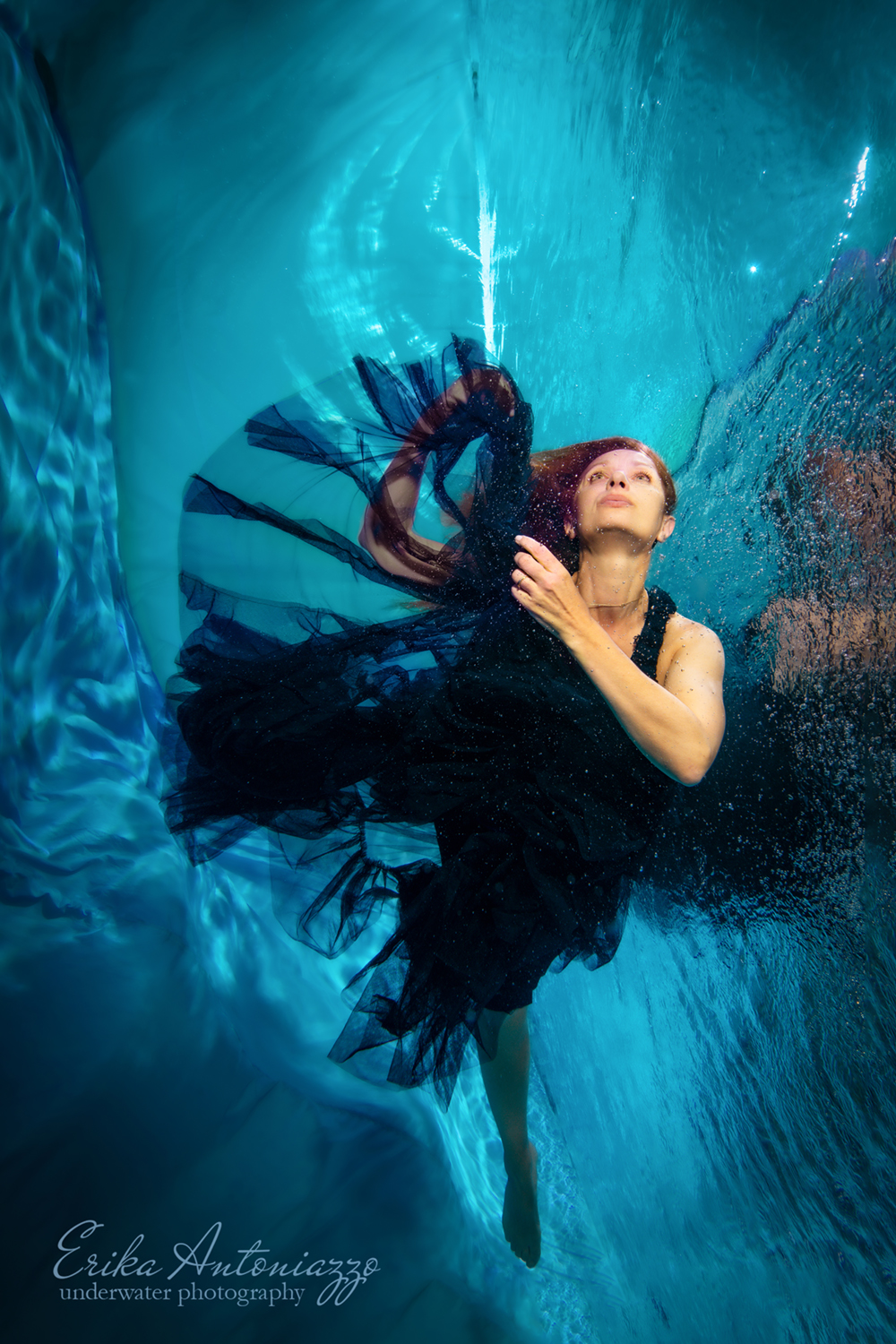 Onderwaterfoto model jonge vrouw met rood haar in mooie jurk