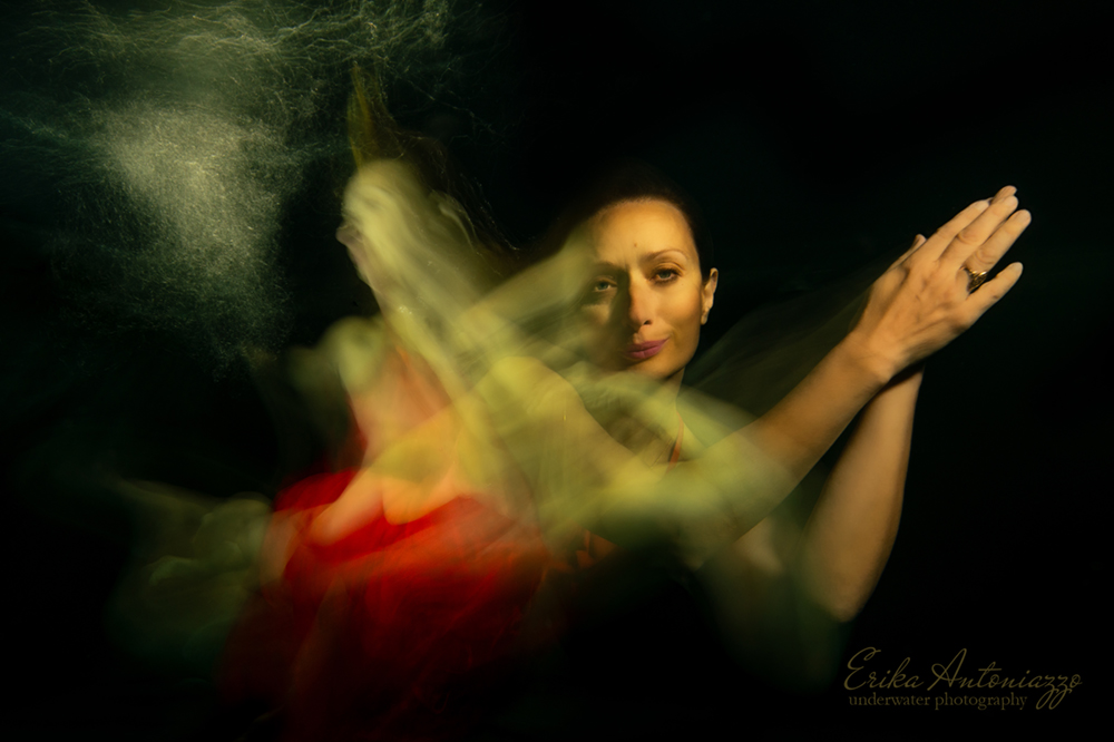 Onderwaterfoto model vrouw in rode jurk, bewogen beeld, artistiek